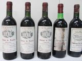 six bottles of wine are lined up in a row on a table