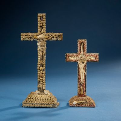 deux croix en bois ornées de perles, posées sur une surface bleue