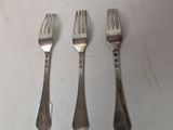 three forks and a knife on a white table