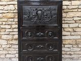 une vieille commode en bois ornée de sculptures sur le dessus