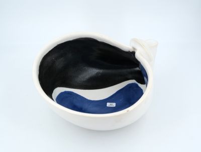 a white bowl with a black and blue whale inside of it