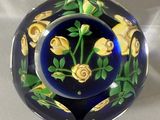 a blue and yellow plate with yellow roses on it