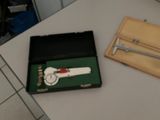 une boîte contenant une montre et une paire de ciseaux, posée sur une table