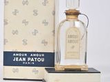 un flacon de parfum posé sur un livre, à côté d'une boîte