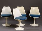 three tulip chairs with blue cushions and a white base