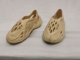 deux paires de chaussures dans lesquelles on a découpé des trous, posées sur une surface blanche