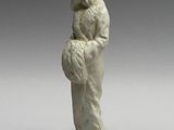 a white figurine of a woman holding a bird