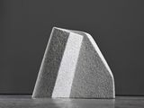 photograph of a block of concrete sitting on top of a concrete floor