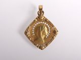 une image représentant un pendentif en or avec le visage d'une femme au centre