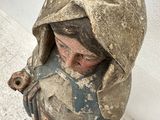 an old statue of a woman with a hood on her head