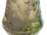 a vase with a picture of a river and trees on it