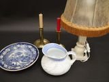 une table sur laquelle se trouvent une lampe, une assiette et une tasse