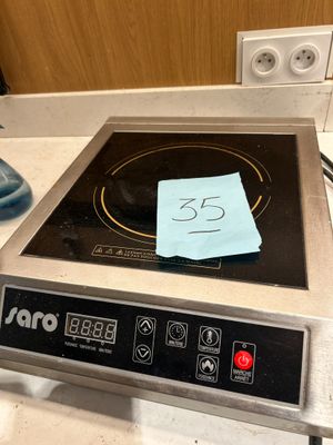 une cuisinière noire et argentée avec un mot posé sur le brûleur
