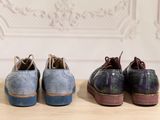 three pairs of shoes sitting on top of a wooden table