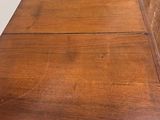 a close up of a wooden table with a blue chair in the background