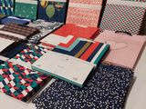 a table topped with lots of different types of notebooks on top of a white table
