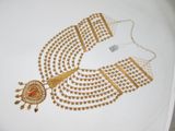 une image représentant un collier en or orné d'une pierre rouge au centre