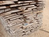 a pile of wood sitting on the ground in front of a building