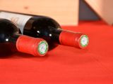 two bottles of wine sitting on a red table