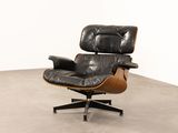 an image of a black leather lounge chair with a wooden base