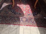 une table et des chaises dans une pièce avec un tapis au sol