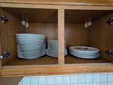 un placard contenant des assiettes et des bols, dans la cuisine