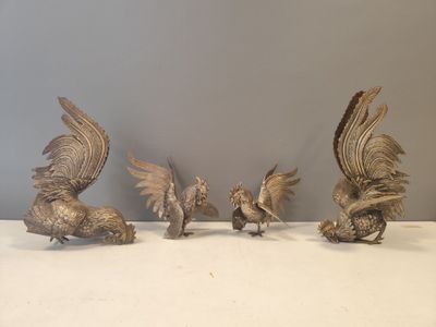 five silver figurines of birds sitting on a table