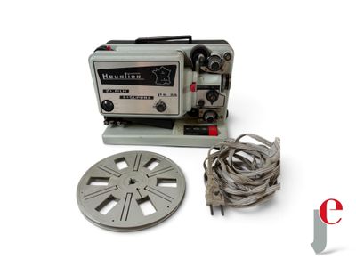 an old movie projector sitting next to a reel and a cable