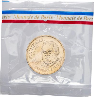 un gros plan d'une pièce de monnaie dans un sachet en plastique sur fond blanc