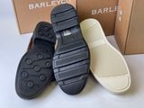 three pairs of black and white shoes sitting on top of a box