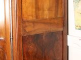 a large wooden armoire in a room with pictures on the wall