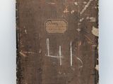 an old book with writing on it sitting on a table