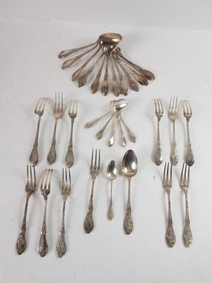 many forks and spoons laid out on the table