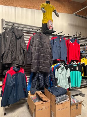 un présentoir de vêtements dans un magasin, surmonté d'un mannequin