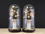 deux vases contenant des fleurs, posés sur une table