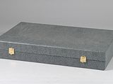 a gray box with gold handles sitting on a white surface