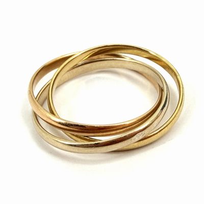 a close up of three gold rings on a white surface