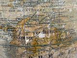 a close up of a globe on a wooden stand
