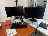 un bureau sur lequel se trouvent deux écrans d'ordinateur et un téléphone