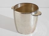 a silver cup with a handle sitting on a table