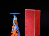 une boîte rouge et un vase bleu posés l'un à côté de l'autre