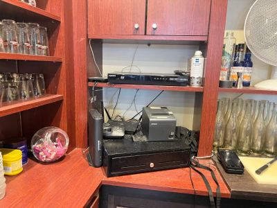 a desk with a printer and a fan in the corner