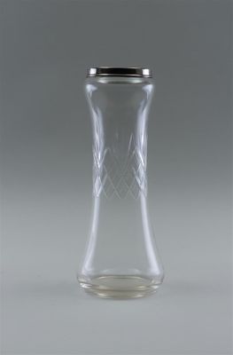 a clear glass vase with a black lid on a table