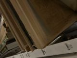 a person that is holding a book on a shelf