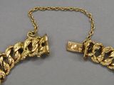 two pieces of gold necklaces on a chain with a lock