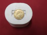 a gold coin sitting on top of a white box
