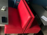 two red chairs next to a table with a cell phone on it