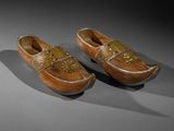 pair of wooden clogs with floral decoration on the sides