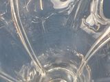 a clear glass bowl with a spoon inside of it