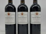 trois bouteilles de vin rouge posées côte à côte sur une table